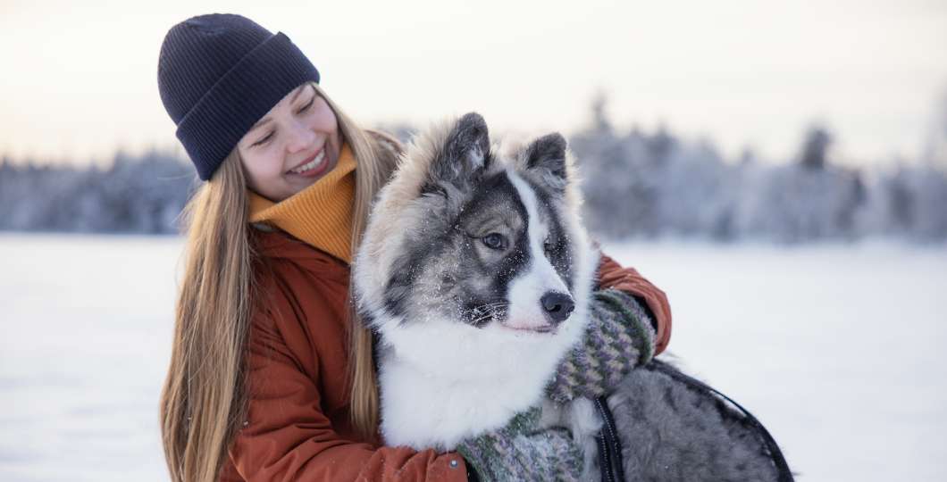 Tyttö ja koira talvisessa maisemassa Kuusamossa. Kuva Harri Tarvainen.